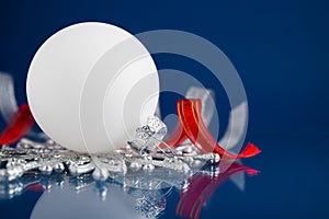 White, silver and red christmas ornaments on dark blue background