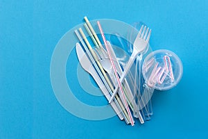 White single-use plastic and plastic drink straws on a blue background. Say no to single use plastic photo