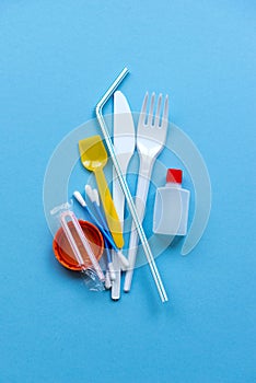 White single-use plastic and plastic drink straws on a blue background. Say no to single use plastic