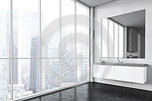 White sink and square big mirror, bathroom with view on the city with skyscrapers