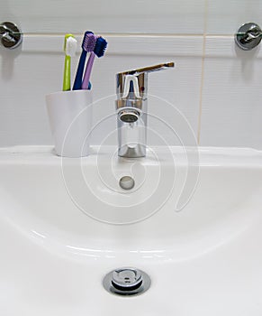 White sink and toothbrushes