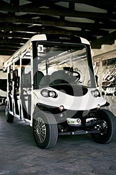 White six-seater golf cart stands in the garage