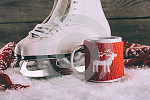 White skates with cup with knitted ornament and scarf