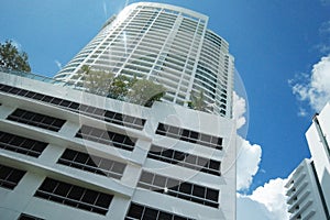 White sky scrapper tall building green trees deep blue skies
