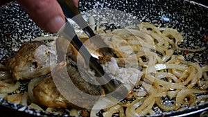 White sliced with half rings onions, fried until golden brown, in frying pan on vegetable oil to caramelize. Floured sea