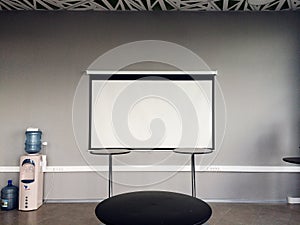 White slide projector screen in the modern building interior.