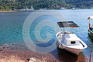 White small boat moored on the shore of the sea bay