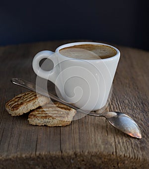 White small cup of espresso with cookies and spoon