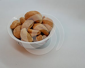 White small porcelain bowl filled with cashew nuts. Natural vitamin. Healthy food. vegetarian food.