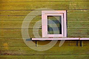White small window on the green wall of a wooden kiosk