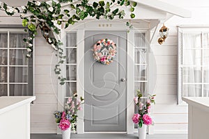 White small wooden house with gray door. spring flower decoration