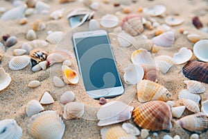 White smartphone lost mobile phone cellphone modern gadget lying on sand beach tropical sunny white sandy seashore