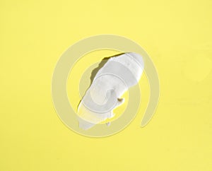 White smear of cosmetic cream on a yellow background. Creamy base texture isolated. A smear of face cream. Close-up of