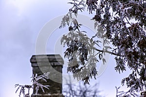 White smoke from the chimney of an old house during frost