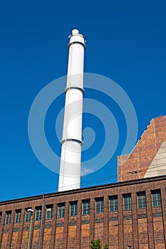 White smokestack and red brick building