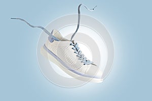 White sneakers flying. Fashionable sports shoes with laces