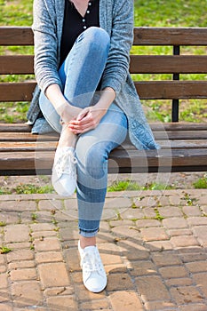 White sneakers on girl legs in blue jeans