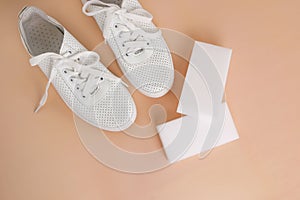 White sneakers with a melamine sponge on a beige background