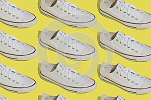 White sneakers pattern. Sports casual shoes on a yellow background.