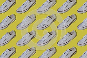 White sneakers pattern. Sports casual shoes on a yellow background.
