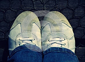 White Sneakers Sport leather shoes walking on old wooden wired bridge.