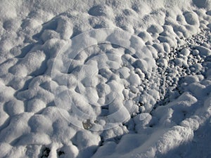 White snow forming round bumps on the ground