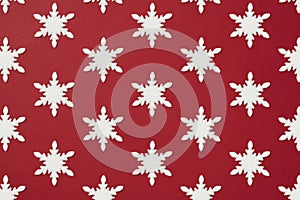 White snowflake shape Christmas ornament flat lay on red background