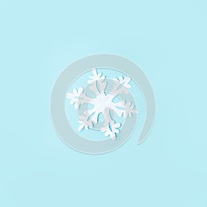 White Snowflake cut from paper on blue background. A traditional Christmas arts and crafts easy diy project. Banner for your site