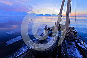 White snowy mountain, blue glacier Svalbard, Norway. Ice in ocean. Iceberg twilight in North pole. Pink clouds, ice floe. Beautifu