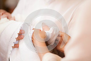 White sock on babys foot with mother hands taking care of child
