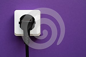 white socket and black plug  on purple background