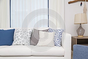 White sofa with many blue pillows in cozy living room