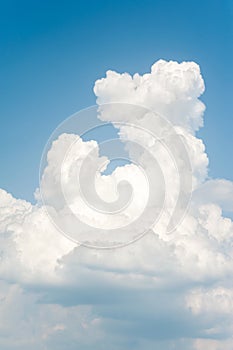 White soft cumulus congestus clouds on blue sky background.