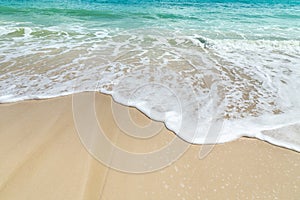 White soft wave in turquoise sea rolling splash on empty tropical sandy beach