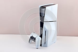 The white Sony PlayStation 5 and controller on the white table.