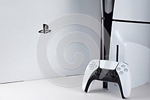 The white Sony PlayStation 5 and controller on the white table.