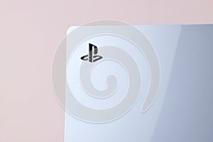 The white Sony PlayStation 5 and controller on the white table.