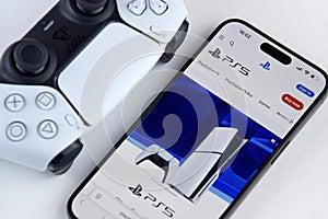 The white Sony PlayStation 5 and controller on the white table.