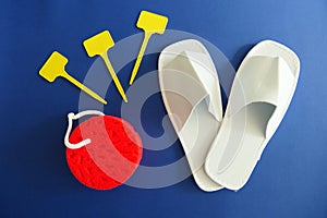White Spa Slippers with New Red Sponge and Empty Yellow Labels isolated on Blue Background