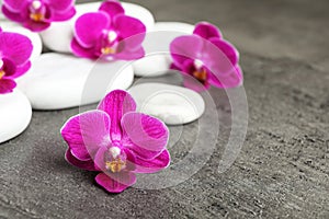White spa stones and orchid flowers on background