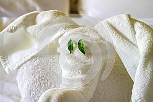White spa towel twisted in the form of an elephant, head with green eyes closeup