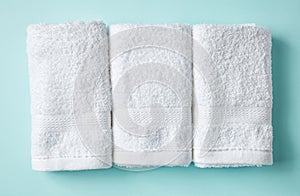 White spa towels on blue, from above