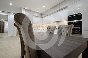 White spacious kitchen interior with dining room table and chairs