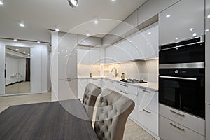 White spacious kitchen interior with dining room table and chairs