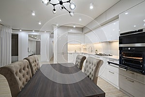 White spacious kitchen interior with dining room table and chairs