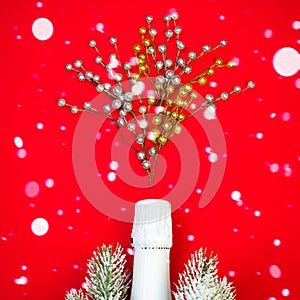 White Sparkling wine bottle on red background with snow and decor, Christmas concept