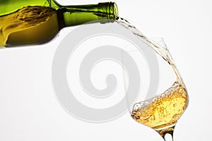 White sparkling wine pouring from green bottle.