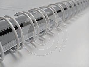 White spiral wire windings in the holes of a notebook