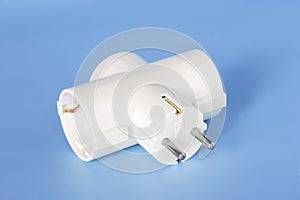 White splitter for 220 volt electricity grid on a blue background. Splitter for simultaneous switching of three electrical