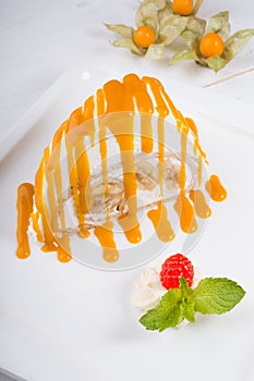 White spoonge peice of cake with orange syrup